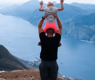 a man holding a little girl up in the air