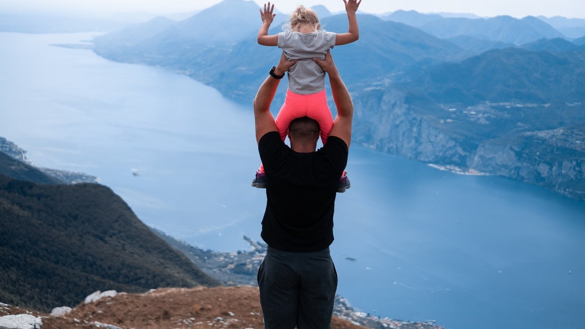 a man holding a little girl up in the air
